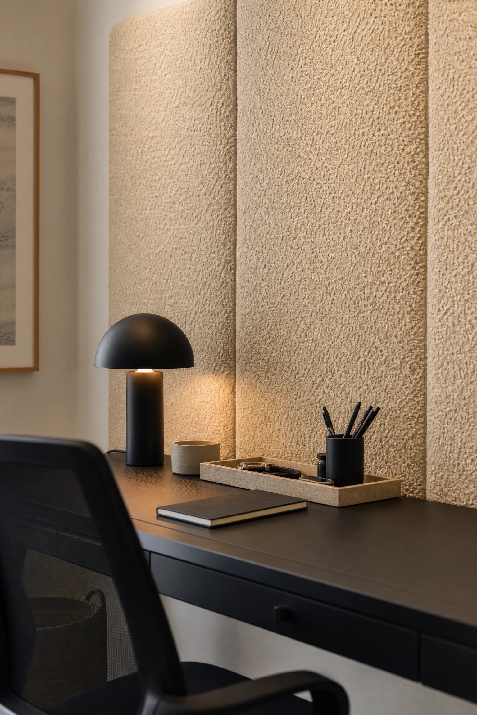 acoustic design: beige boucle wall panels behind a black desk in a office