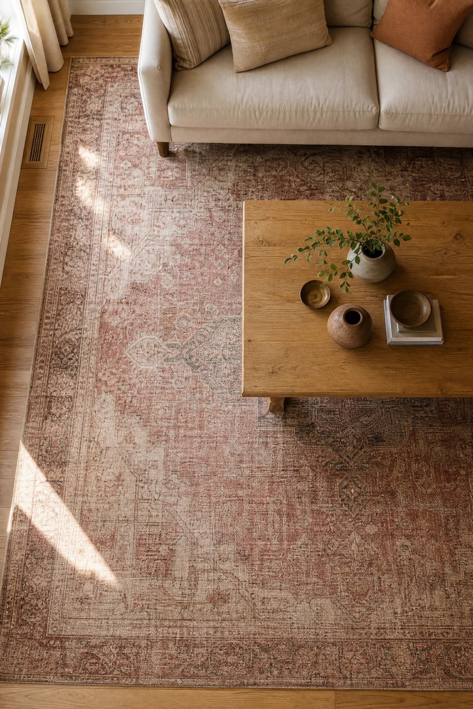 a pink and beige vintage-style rug as the room's foundation in a living room
