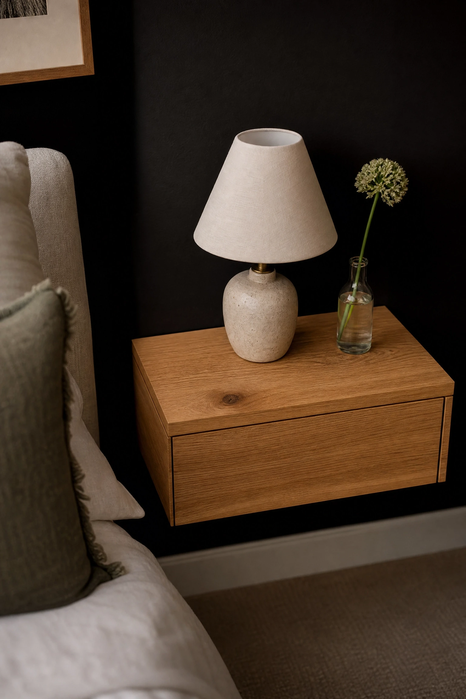 black wall paired with warm oak or walnut bedside tables in a bedroom
