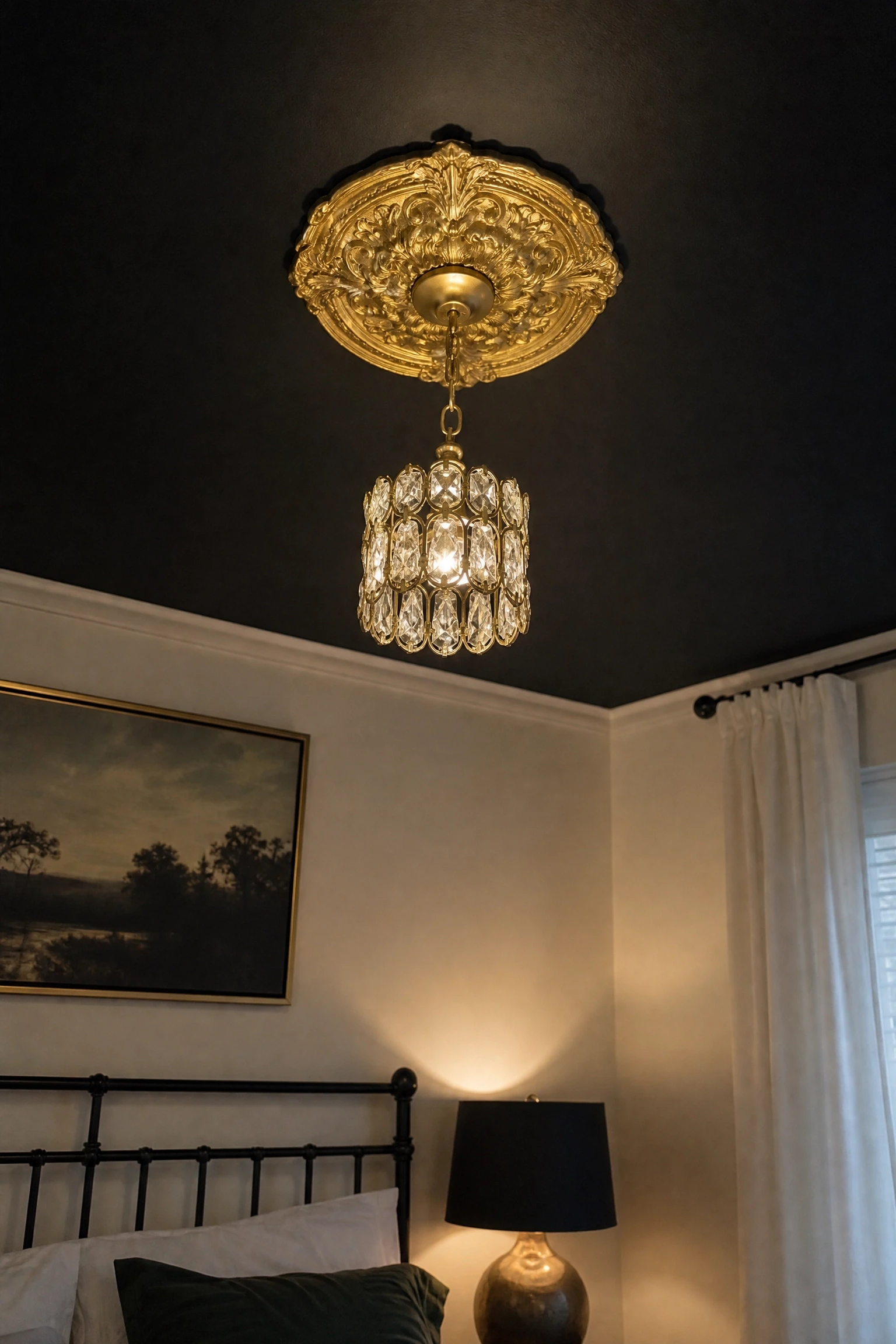 the ceiling feels forgotten: paint it a deep charcoal and add a gold fixture in a bedroom