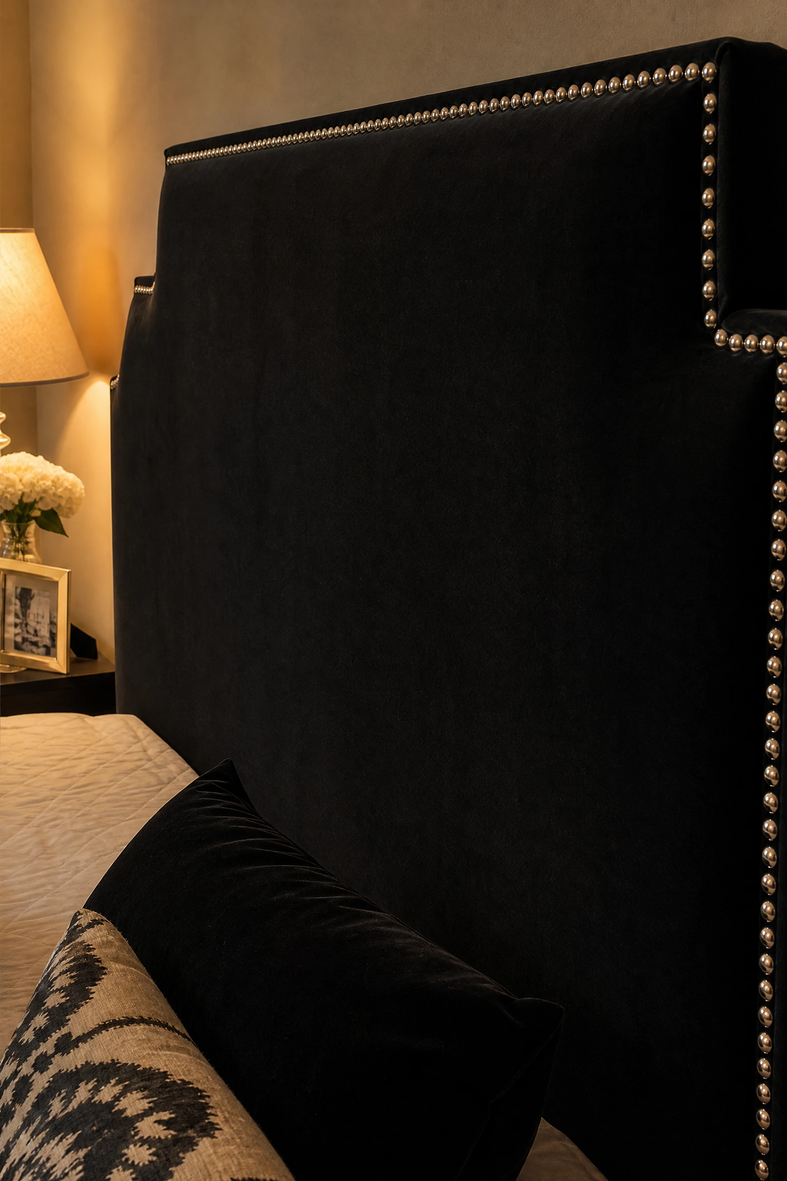 black bedframe with silver nailhead trim detail in a bedroom
