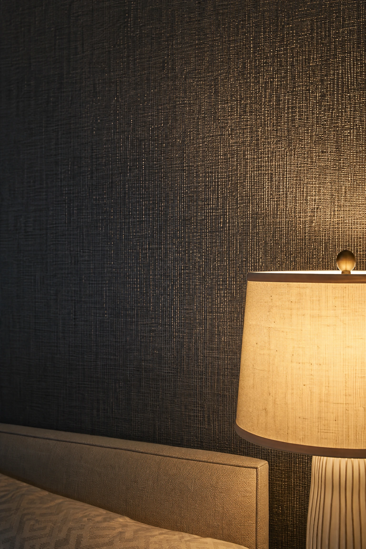 black textured wallcovering with silver thread in a bedroom