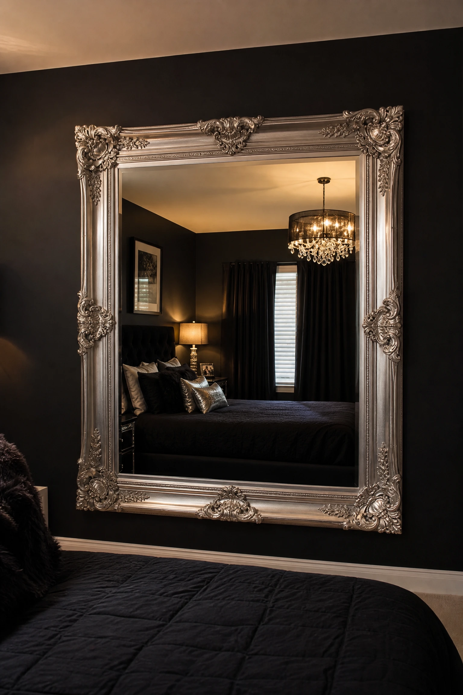 black walls with a single large silver mirror in a bedroom