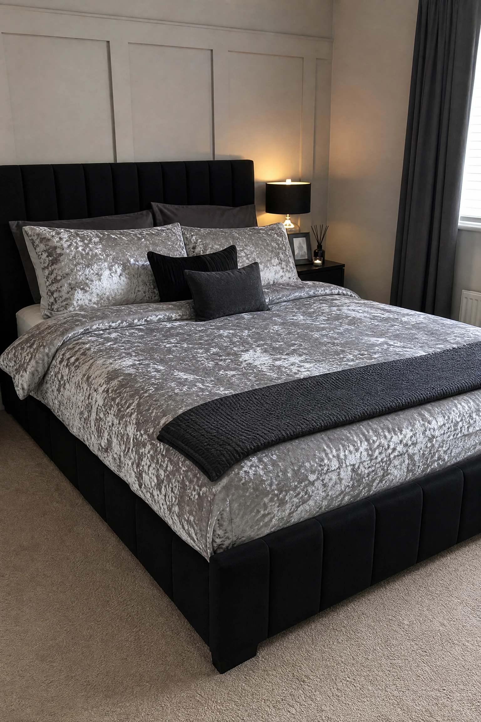 silver bedding with a charcoal or black bed frame in a bedroom