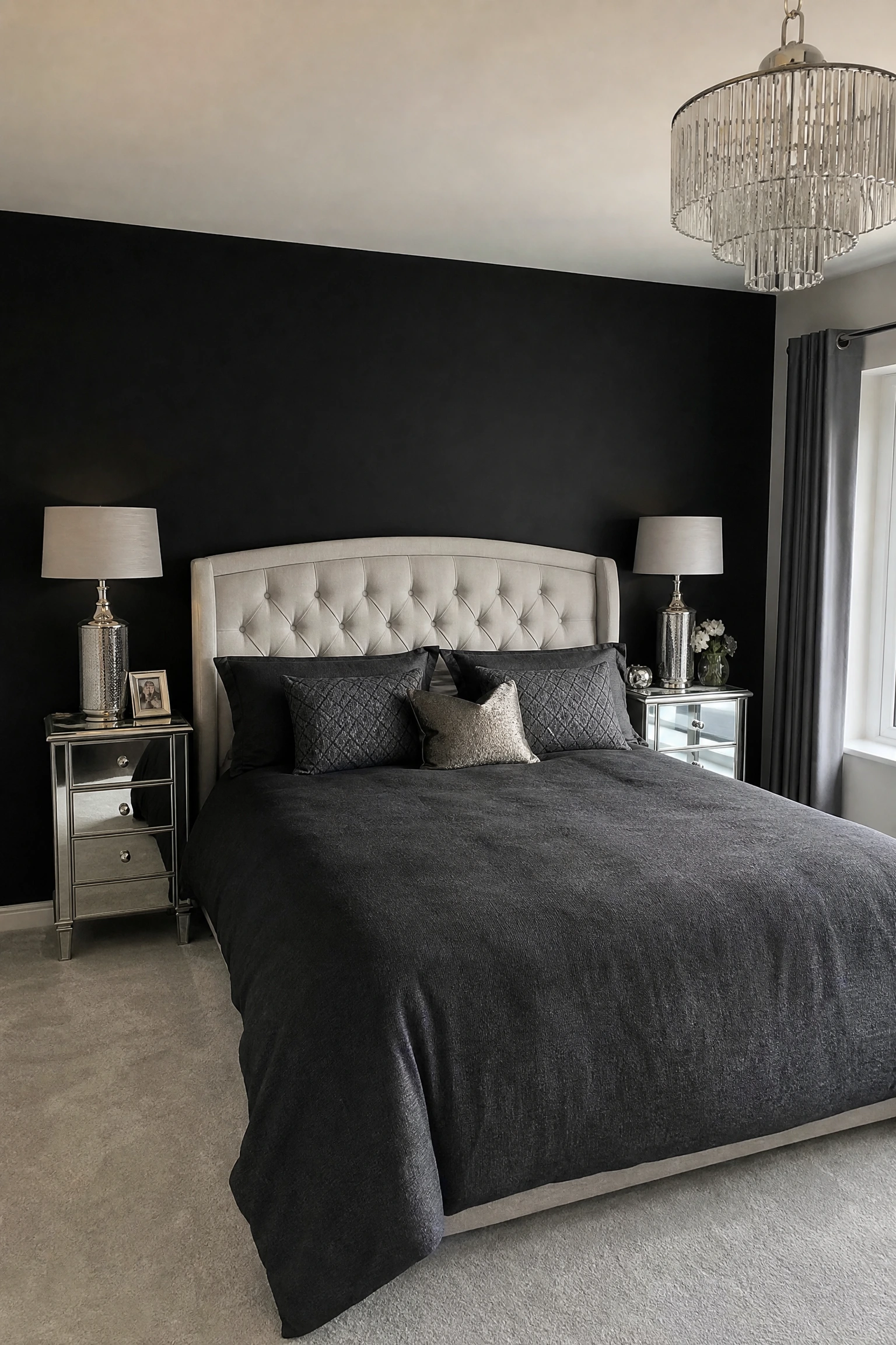 silver mirrored furniture against a black accent wall in a bedroom
