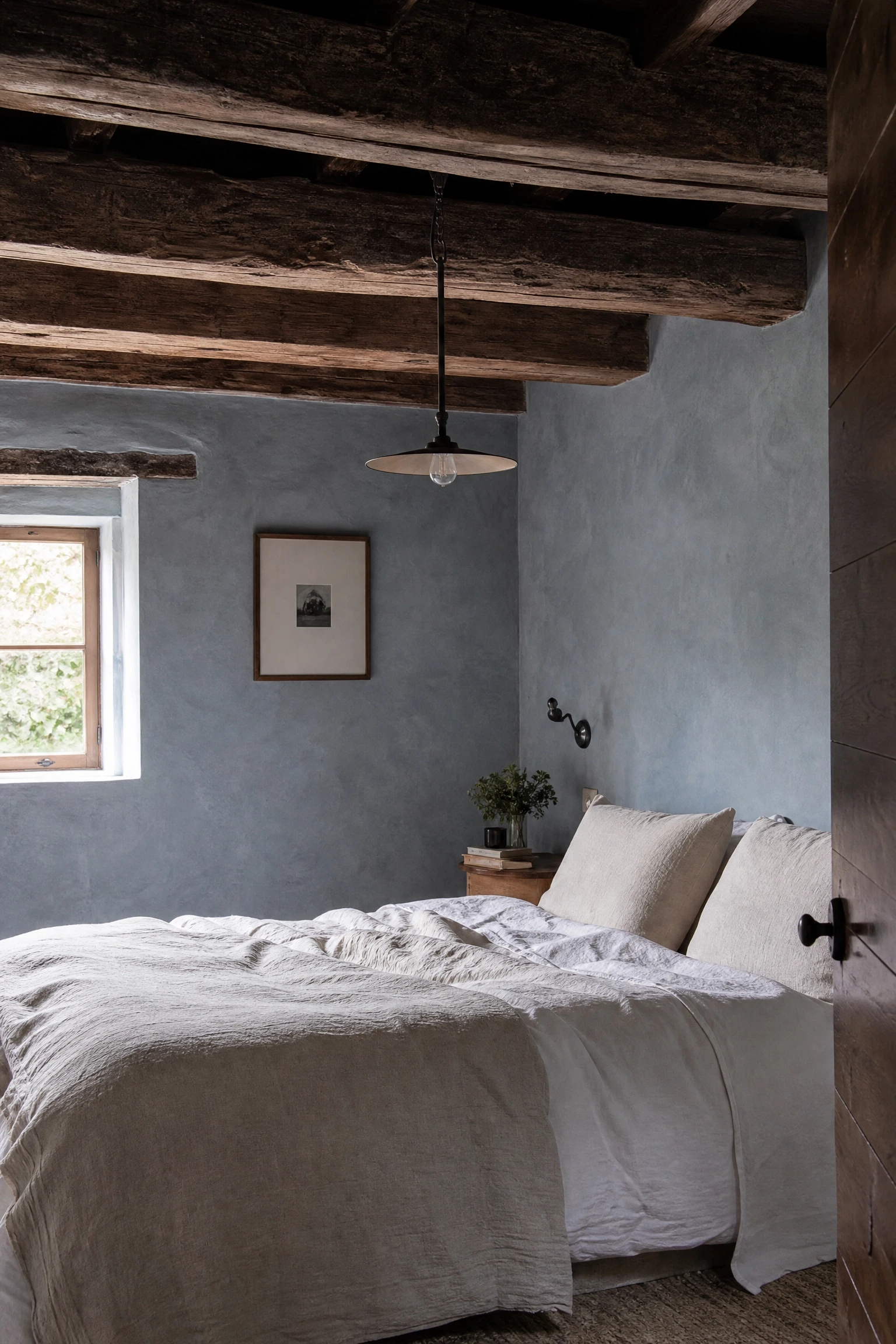 blue-grey limewash walls with exposed timber beams in a bedroom
