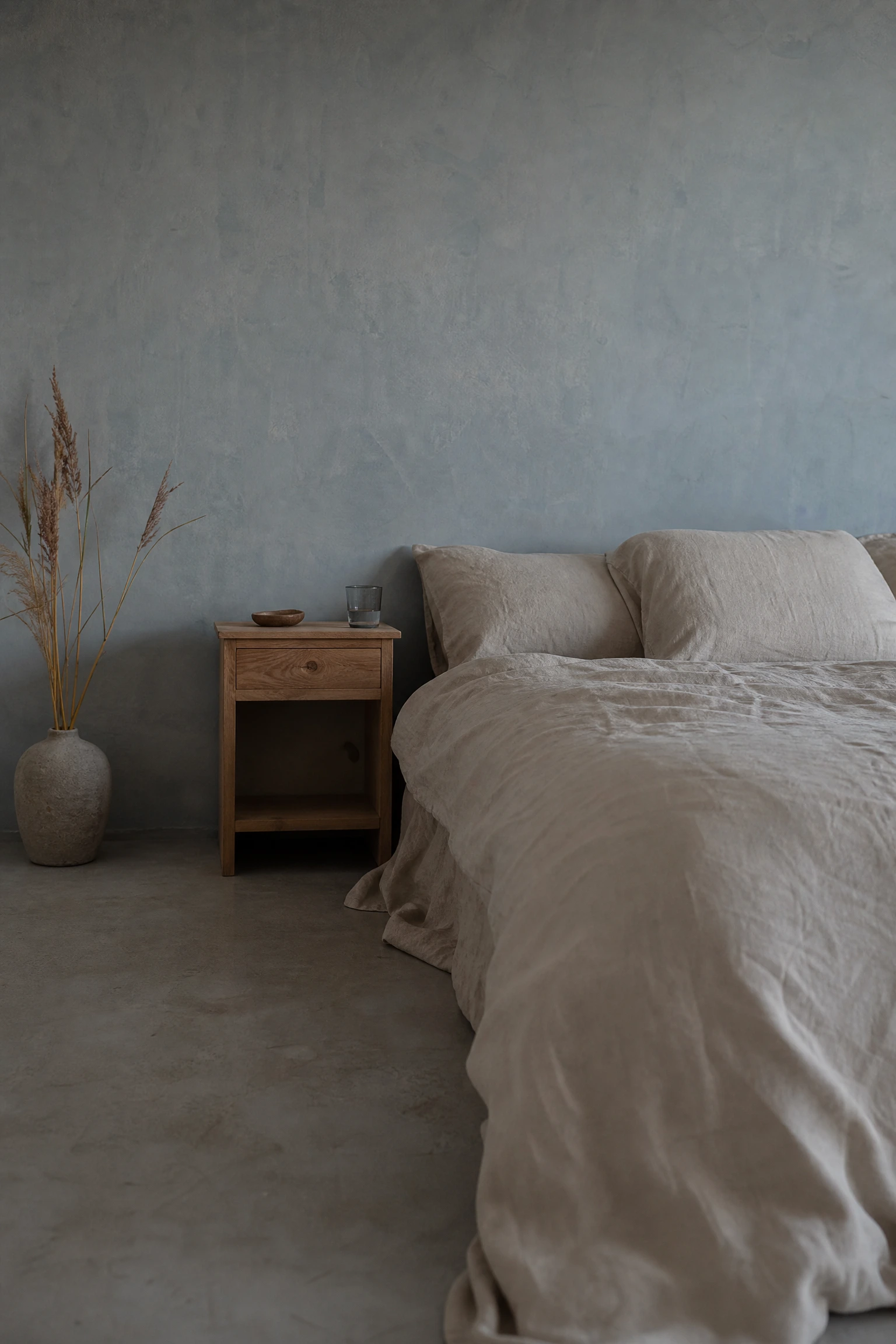 washed blue-grey walls with unfinished linen and wood in a bedroom