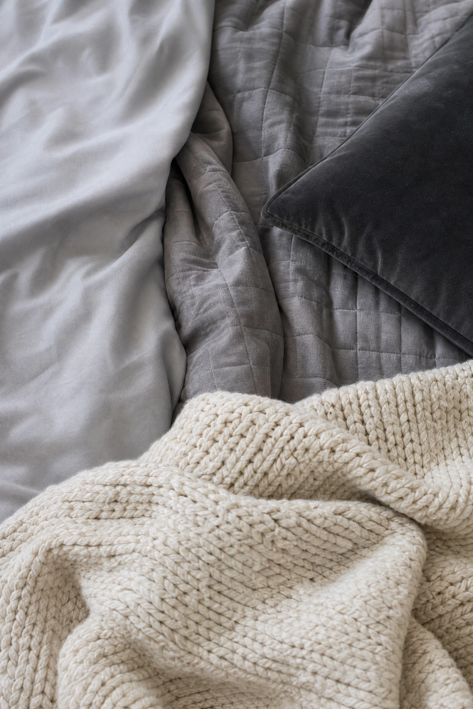 add texture through varied fabric weights on the bed in a bedroom