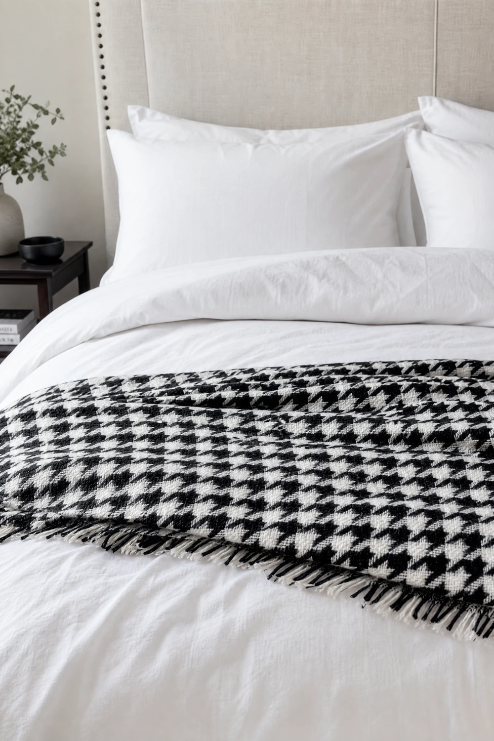 crisp white bedding with a black geometric throw in a bedroom