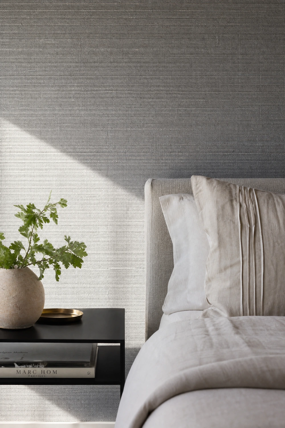 grey grasscloth or textured wallpaper on the bed wall in a bedroom