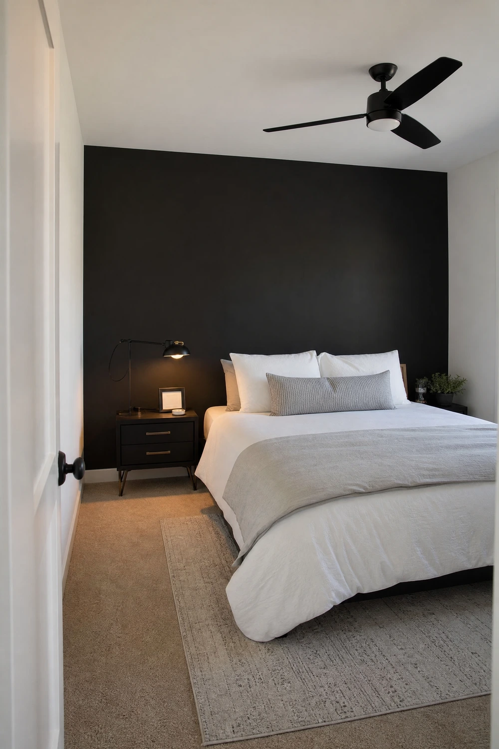 one matte black accent wall behind the bed, everything else light in a bedroom