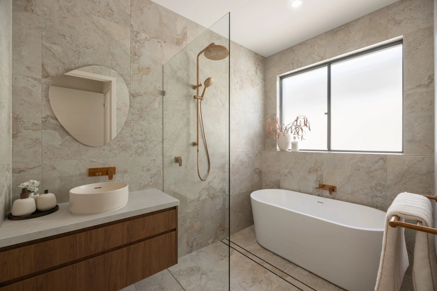Travertine-look tiles covering a beige bathroom from floor to shower