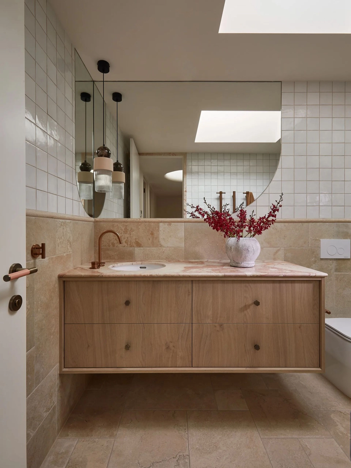 Light oak vanity against white tiled bathroom walls