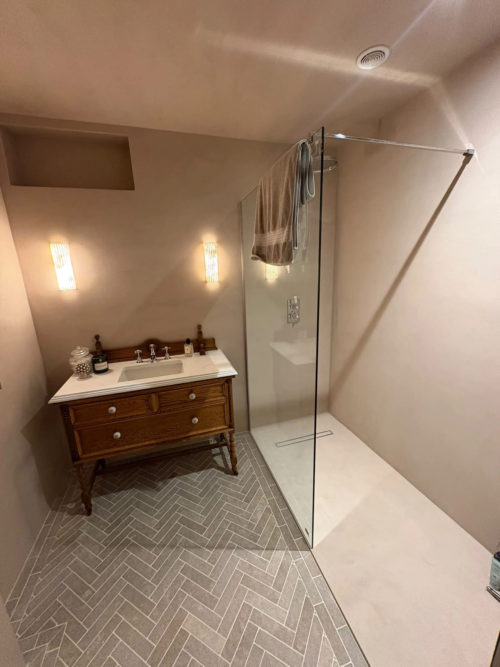 Beige microcement bathroom walls with a vintage wood vanity