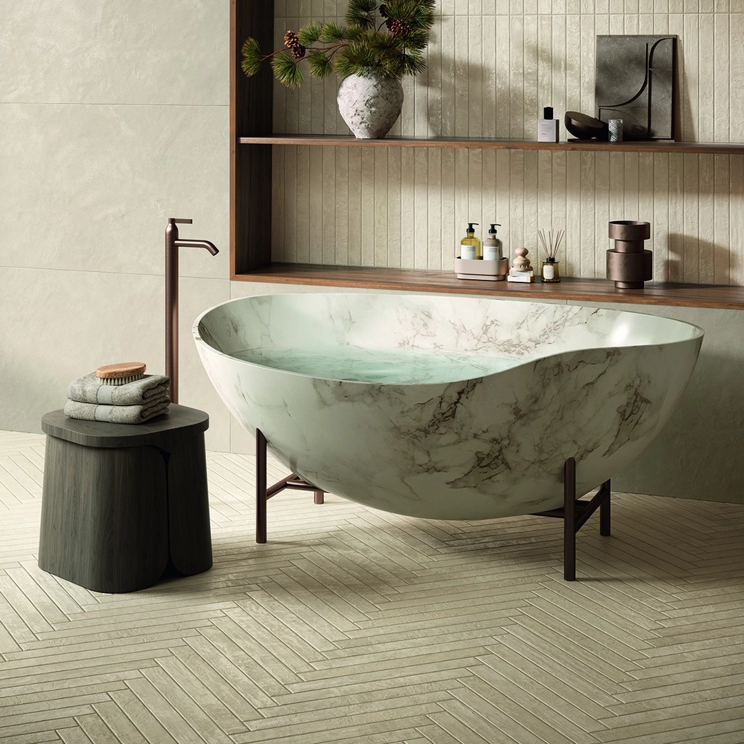 Creamy beige floor tiles under a marble freestanding tub