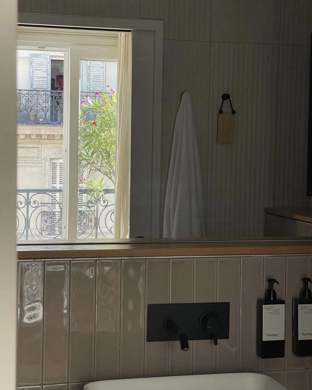 Matte black wall-mounted faucet on glossy beige bathroom tiles