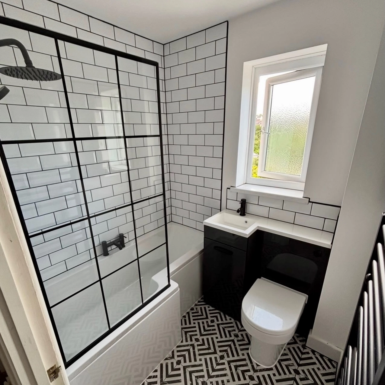 White subway tiles with dark grout lines and black fixtures