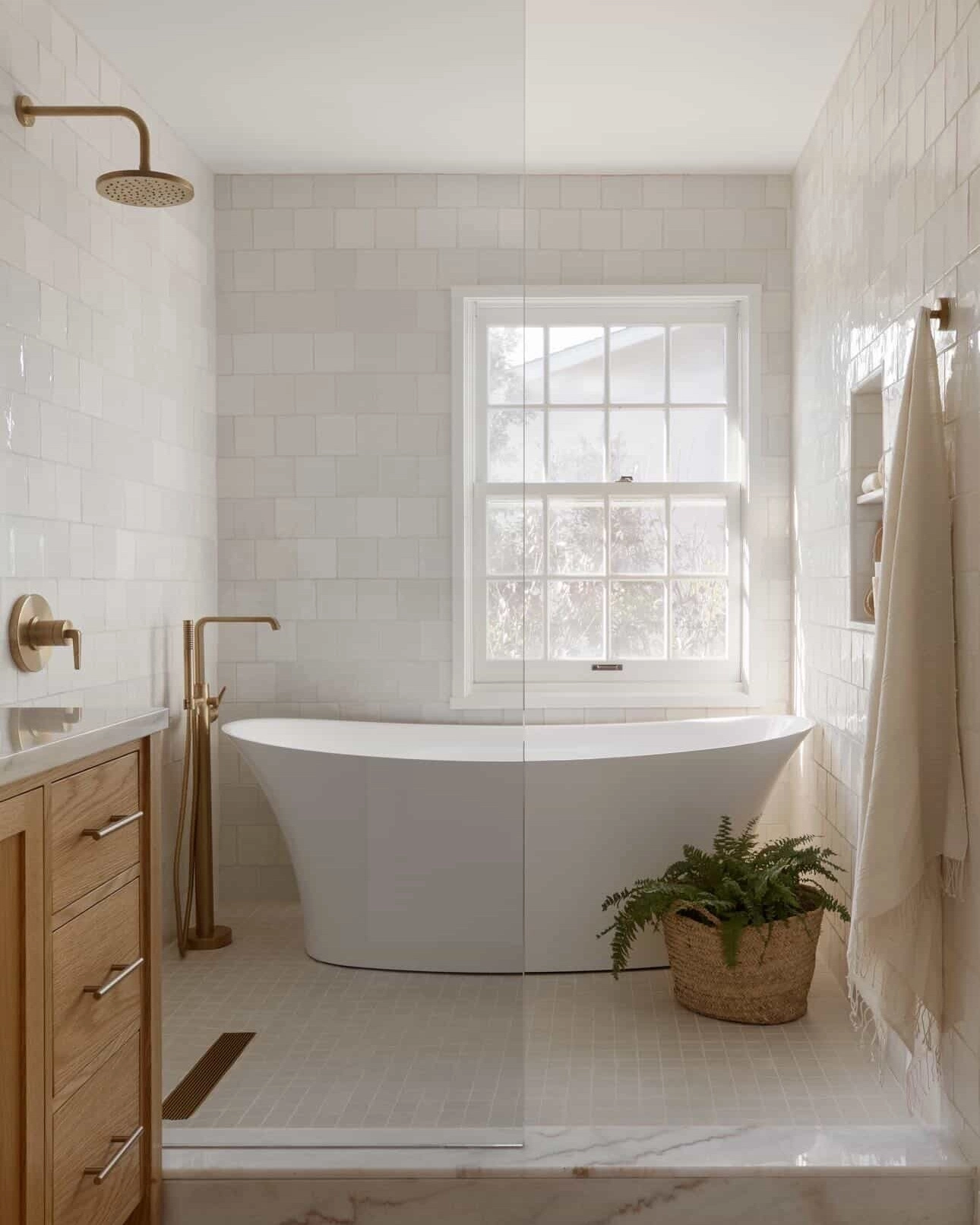 Glossy white tiles bouncing window light around a bathtub